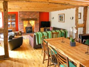sala de estar con sofá, mesa y chimenea en Ysgubor Pwlliago, en Pennant-Melangell