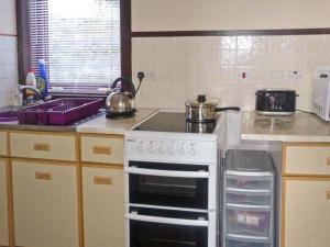 a kitchen with a stove with two pots and pans at Pool House in Midtown Brae