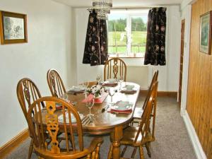 a dining room with a wooden table and chairs at Bryn Re in Trawsfynydd