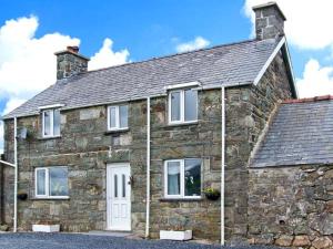 an old stone house with white doors and windows at Bryn Re in Trawsfynydd