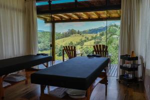 a room with a table and chairs and a large window at Pousada Estância das Montanhas in Águas de Lindoia