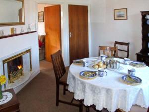 uma sala de jantar com uma mesa e uma lareira em Loningside em Wombourn