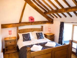 a bedroom with a wooden bed with two night stands at Bwthyn Y Wennol in Llanddulas