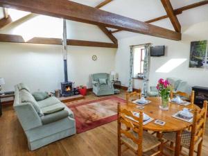a living room with a table and a fireplace at Muncaster View in Drigg