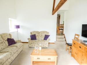 a living room with a couch and a coffee table at Ghyll Bank Byre in Staveley