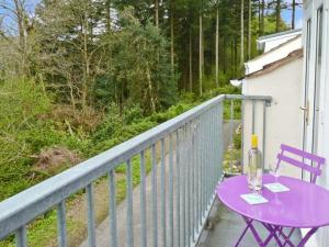 a purple table with a bottle of wine on a balcony at 15 Forest Park Lodges in High Bickington