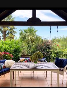 a patio with a bench and a table with plants at El Rincón de las Marismas in Carasa