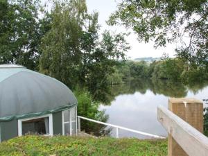 a gazebo next to a body of water at Lakeview Yurt in Beckford