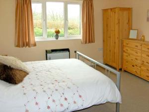 Un pat sau paturi într-o cameră la Ffynnon Dewi