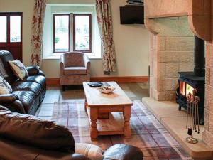 a living room with a couch and a fireplace at Orcaber Cottage in Austwick