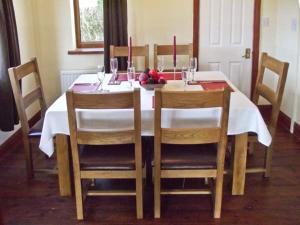 a dining room table with two chairs and a white table cloth at Hartam House in Falstone
