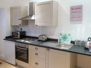 a kitchen with a sink and a stove top oven at No 5 The Stables in Pateley Bridge