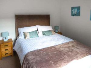 a bedroom with a large bed with two pillows at No 5 The Stables in Pateley Bridge