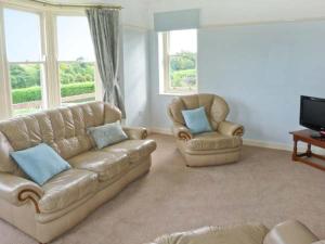 a living room with a couch and two chairs at Priory View in Bardsea