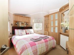 a bedroom with a bed with towels on it at The Four Oaks Chalet in Fassfern