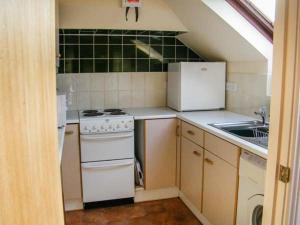 a small kitchen with white appliances and a sink at Uplands in Compton