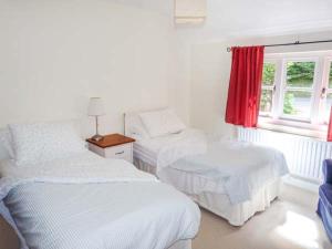 een slaapkamer met twee bedden en een raam bij Woodhill Cottage in Holmbury Saint Mary