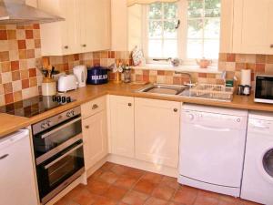 a kitchen with a sink and a dishwasher at The Cygnet in Haselbury Plucknett