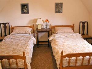 a bedroom with two beds and a table with a lamp at The Cygnet in Haselbury Plucknett