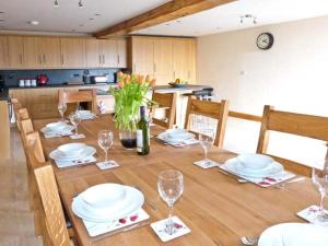 a dining room table with plates and wine glasses at Riddings Barn in Low Borrowbridge
