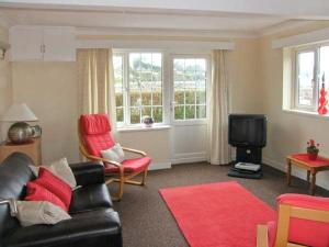 a living room with a couch and a tv at Glan Y Don Bach in Abersoch