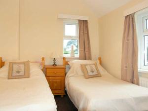 a bedroom with two beds and a window at Glan Y Don Bach in Abersoch