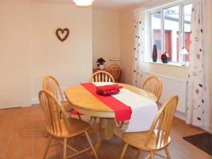 a dining room with a wooden table and chairs at Glan Y Don in Abersoch