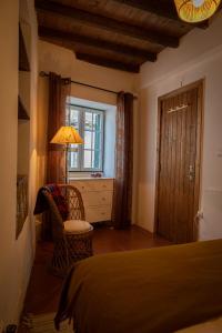 a bedroom with a bed and a table and a lamp at A Casa da Ti Vina in Gavião