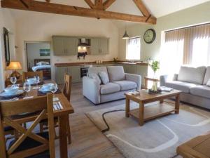 uma sala de estar com um sofá e uma mesa em Berringtons Barn em Lockleywood