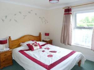 a bedroom with a bed with a red and white blanket at Stonewind Farm in Freshwater