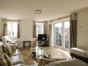 a living room with a couch and a glass table at Mill Lodge in Brisley