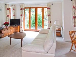 a living room with a white couch and a tv at 9 Bancroft Place in Stratford-upon-Avon