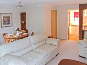 a living room with a white couch and a table at 9 Bancroft Place in Stratford-upon-Avon