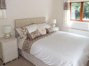a bedroom with a white bed with pillows and a window at 9 Bancroft Place in Stratford-upon-Avon