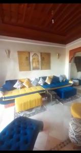 a living room with blue and yellow couches at marrakech palmeraie village Etablissement jasmin in Marrakech