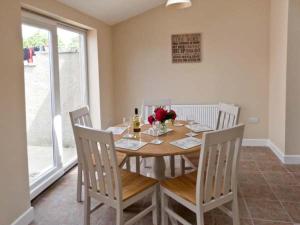 a dining room with a table and chairs with flowers on it at 4 Helwith Bridge Cottages in Horton in Ribblesdale