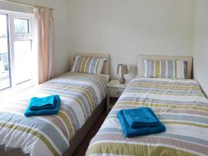 two beds with towels on them in a bedroom at 4 Helwith Bridge Cottages in Horton in Ribblesdale