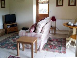 - un salon avec un canapé et une table dans l'établissement Hollins Wood Bothy, à Wortley