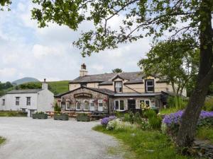 ein großes Haus mit einer Einfahrt davor in der Unterkunft 4 Helwith Bridge Cottages in Horton in Ribblesdale