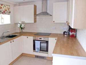 eine Küche mit weißen Schränken und einer Arbeitsplatte in der Unterkunft Hollins Wood Bothy in Wortley