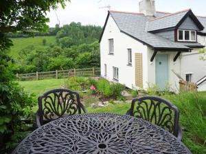 a black table with two chairs and a white house at Greenslades in Exford