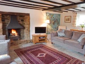 a living room with a couch and a fireplace at Greenslades in Exford