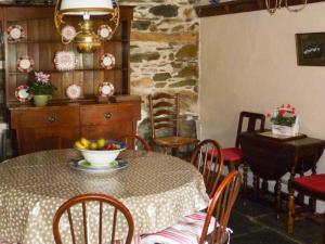 a dining room with a table with a bowl of fruit on it at High Kiln Bank Cottage in Ulpha