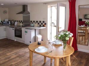 cocina con mesa de madera y comedor en Rowan Studio, en Great Witcombe