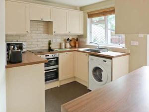 a kitchen with a washing machine and a washer at Back Cottage in Kirkby Lonsdale