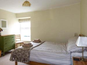カークビー・ロンズデールにあるBack Cottageのベッドルーム1室(ベッド1台、タオル2枚付)