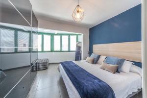 a bedroom with a large bed with blue walls at Luxury Apartment Gueldera in Playa Honda