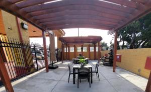 a patio with a table and chairs under a wooden pergola at Mission Inn and Suites in Hayward