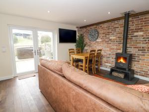 een woonkamer met een bank en een open haard bij Ffynnonlwyd Cottage in Llangynin