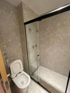 La salle de bains est pourvue de toilettes et d'une douche en verre. dans l'établissement SALINAS PREMIUM RESORT, à Salinópolis